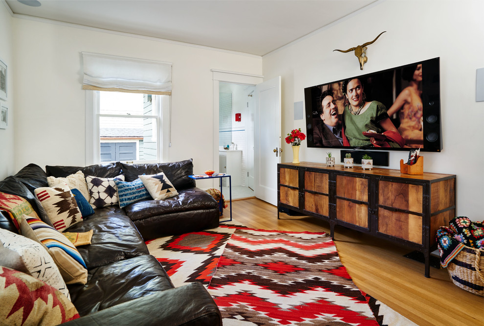Foto de sala de estar cerrada ecléctica pequeña con paredes blancas, suelo de madera en tonos medios, televisor colgado en la pared y suelo marrón