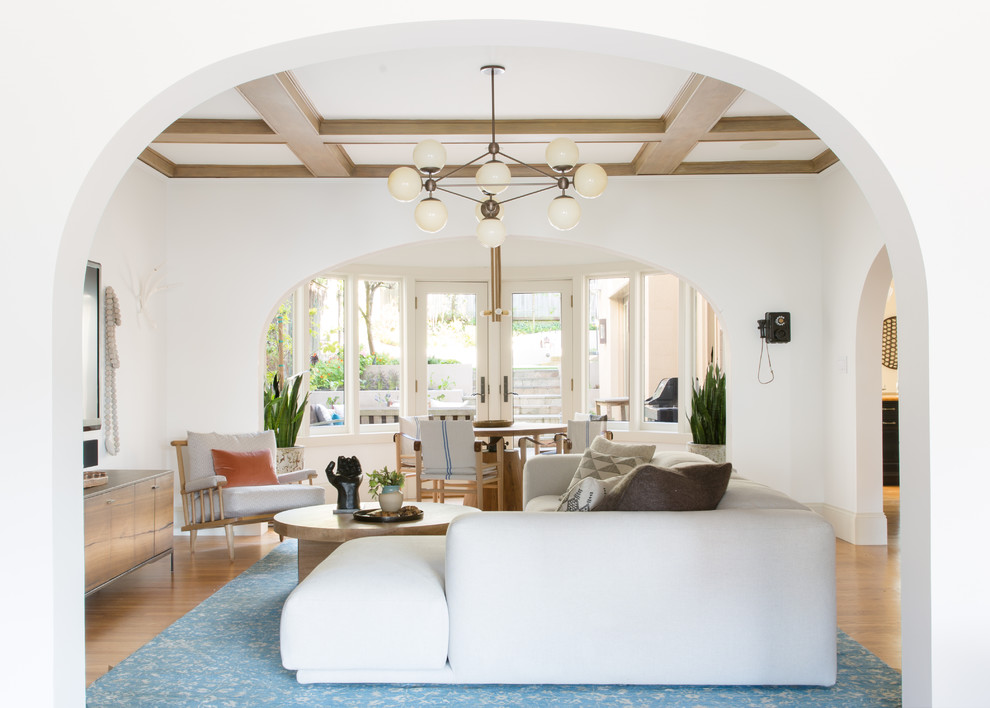 Diseño de sala de estar abierta bohemia grande con paredes blancas y televisor colgado en la pared