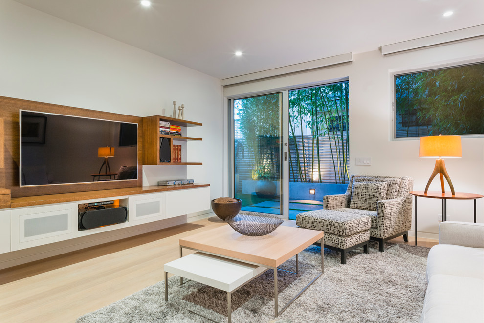 Ispirazione per un soggiorno design con pareti bianche, parquet chiaro, parete attrezzata, pavimento beige e tappeto