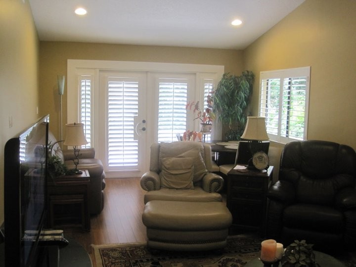 Kleines, Abgetrenntes Klassisches Wohnzimmer mit beiger Wandfarbe, braunem Holzboden und freistehendem TV in Miami