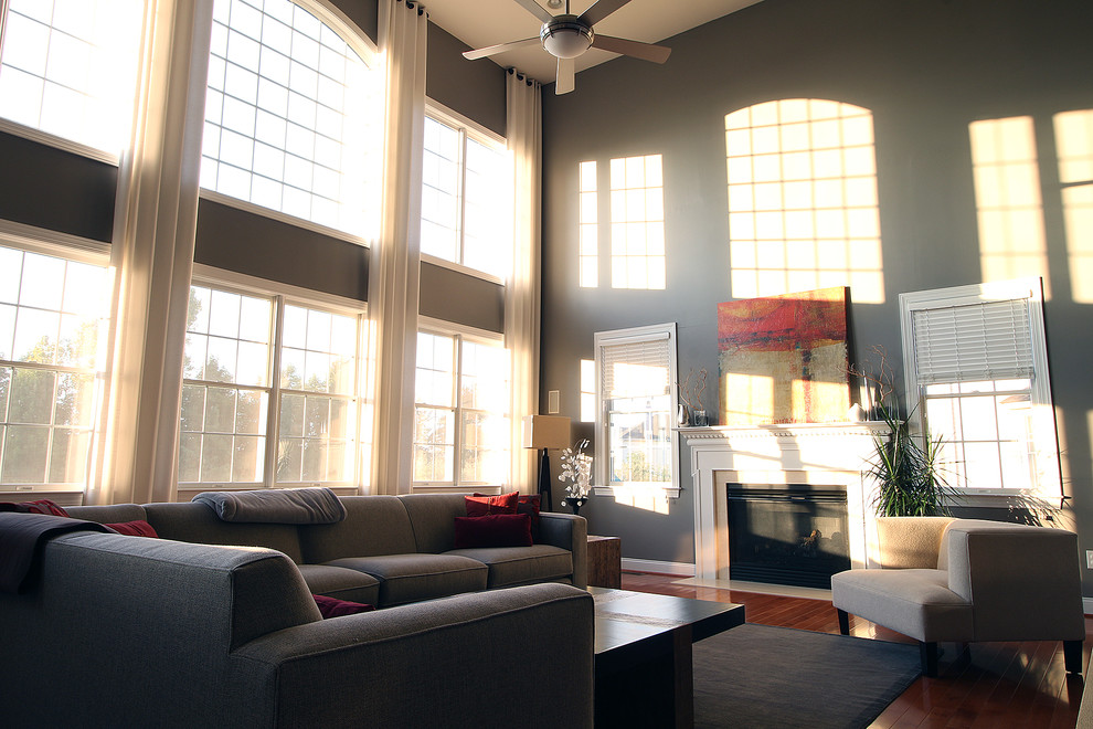 Mittelgroßes, Abgetrenntes Modernes Wohnzimmer mit grauer Wandfarbe, braunem Holzboden, Kamin, Kaminumrandung aus Holz und TV-Wand in New York