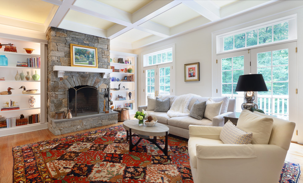 Large elegant enclosed medium tone wood floor and brown floor family room photo in New York with beige walls, a standard fireplace and a stone fireplace