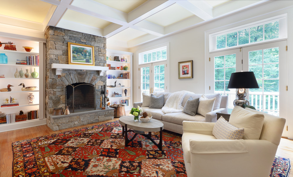 Großes, Abgetrenntes Klassisches Wohnzimmer mit beiger Wandfarbe, braunem Holzboden, Kamin, Kaminumrandung aus Stein und braunem Boden in New York