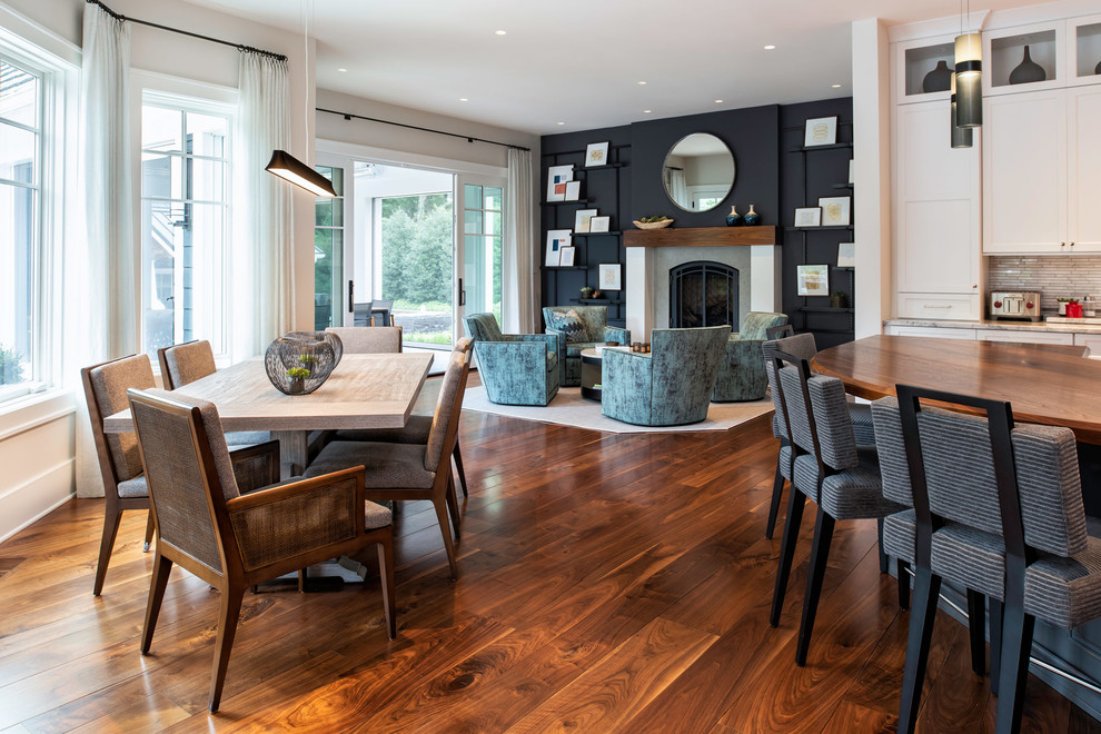 Imagen de sala de estar abierta clásica renovada grande con paredes negras, suelo de madera en tonos medios y suelo marrón