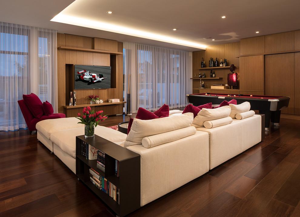 На фото: большая двухуровневая комната для игр в современном стиле с белыми стенами, темным паркетным полом, скрытым телевизором и коричневым полом без камина