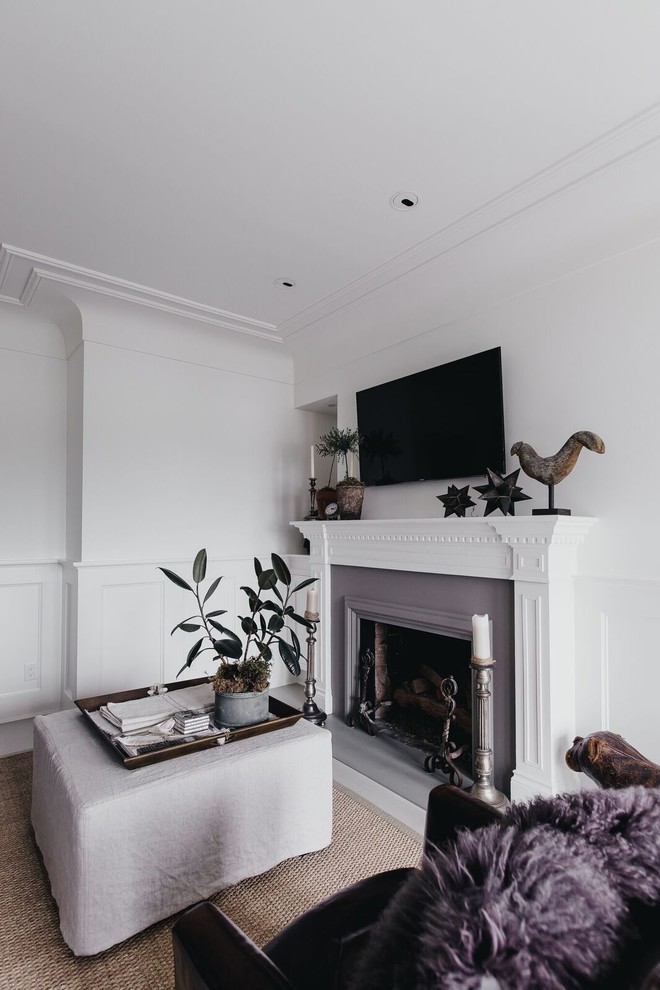 Свежая идея для дизайна: изолированная гостиная комната среднего размера в классическом стиле с белыми стенами, бетонным полом, стандартным камином, фасадом камина из дерева и телевизором на стене - отличное фото интерьера