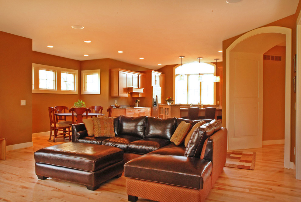 На фото: открытая гостиная комната среднего размера в классическом стиле с коричневыми стенами, светлым паркетным полом, стандартным камином, фасадом камина из камня и отдельно стоящим телевизором