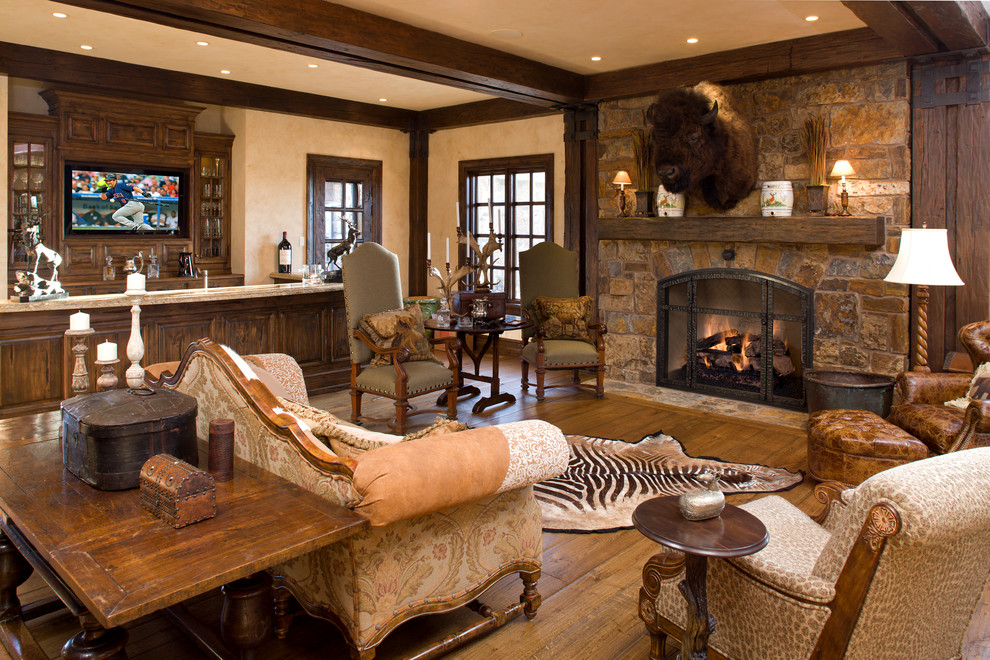 Mountain style open concept medium tone wood floor family room photo in Denver with a bar, beige walls and a standard fireplace