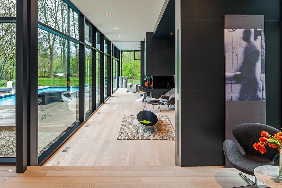 Photo of a large modern open plan games room in Toronto with black walls and light hardwood flooring.