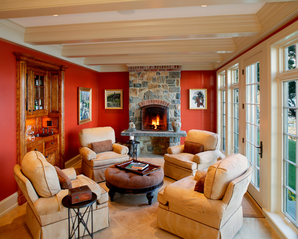 Idée de décoration pour une salle de séjour tradition fermée avec un mur orange, une cheminée standard et un manteau de cheminée en pierre.