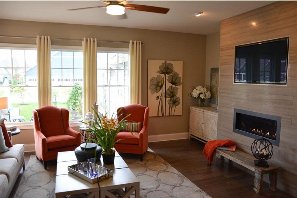 Modelo de sala de estar actual con paredes beige, suelo de madera oscura, chimenea lineal, marco de chimenea de baldosas y/o azulejos y televisor colgado en la pared