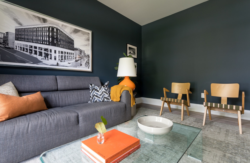 トロントにある低価格の小さなミッドセンチュリースタイルのおしゃれな独立型ファミリールーム (青い壁、無垢フローリング、暖炉なし、壁掛け型テレビ、グレーの床) の写真