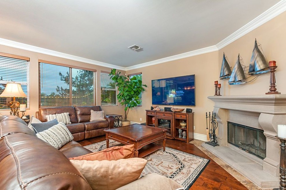 This is an example of a medium sized classic open plan games room in San Diego with a stone fireplace surround.