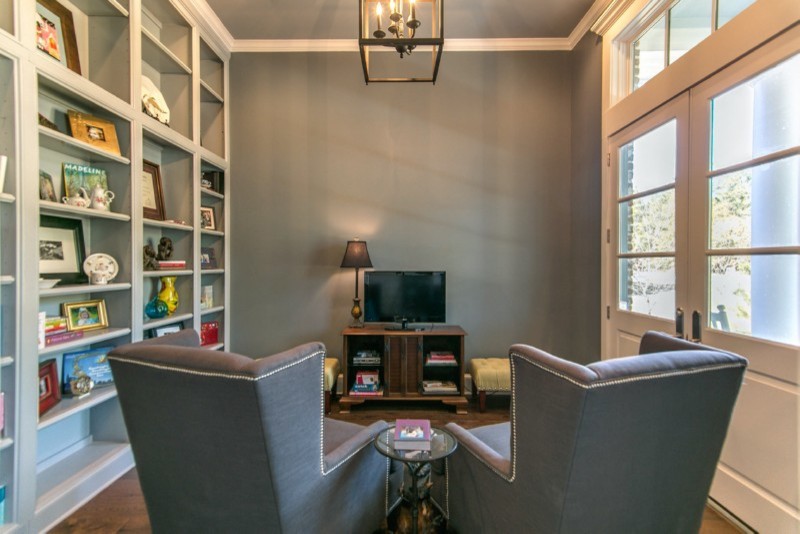 Aménagement d'une petite salle de séjour craftsman fermée avec une bibliothèque ou un coin lecture, un mur gris, parquet foncé, aucune cheminée, un téléviseur indépendant et un sol marron.