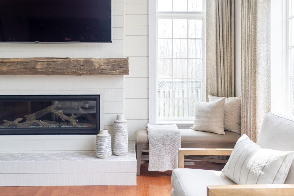 Inspiration for a large transitional open concept medium tone wood floor and orange floor family room remodel in Toronto with beige walls, a standard fireplace, a wood fireplace surround and a wall-mounted tv