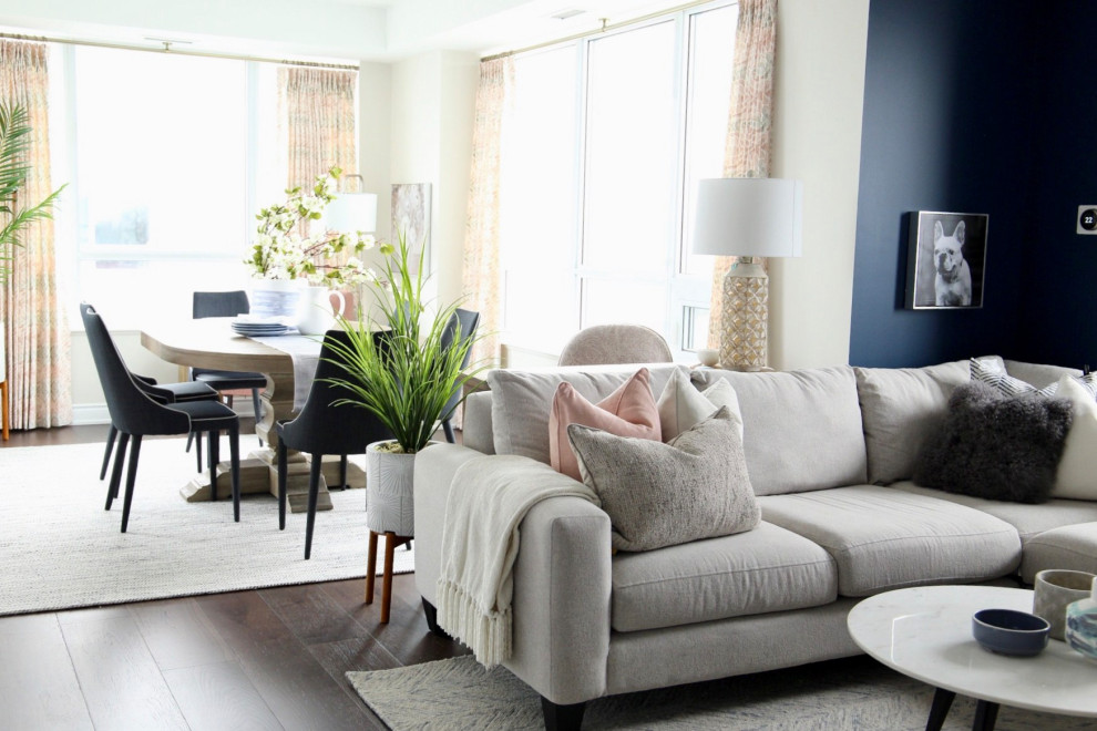 Diseño de sala de estar abierta clásica renovada pequeña con paredes azules, suelo de madera oscura, televisor colgado en la pared y suelo marrón