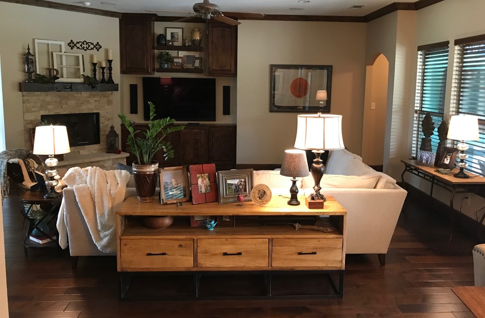 Offenes, Mittelgroßes Klassisches Wohnzimmer mit beiger Wandfarbe, dunklem Holzboden, Kaminumrandung aus Stein, TV-Wand, braunem Boden und Kamin in Dallas
