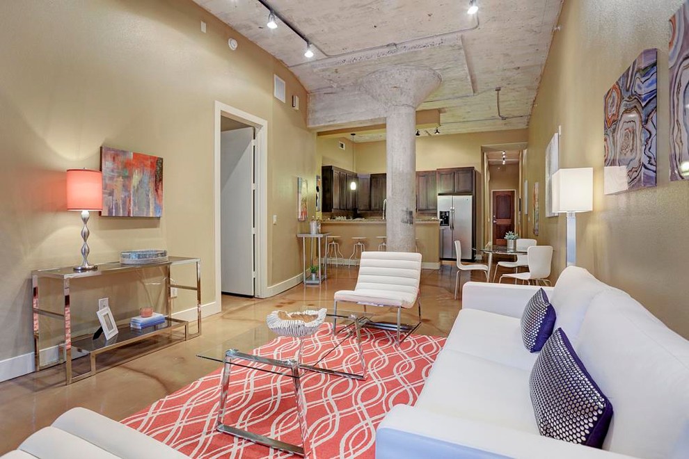 Imagen de sala de estar abierta urbana de tamaño medio sin chimenea y televisor con paredes beige, suelo de cemento y suelo beige