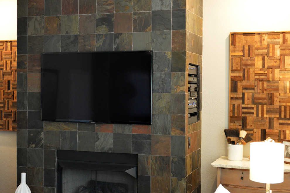 На фото: изолированная гостиная комната среднего размера в стиле кантри с бежевыми стенами, паркетным полом среднего тона, стандартным камином, фасадом камина из камня и телевизором на стене