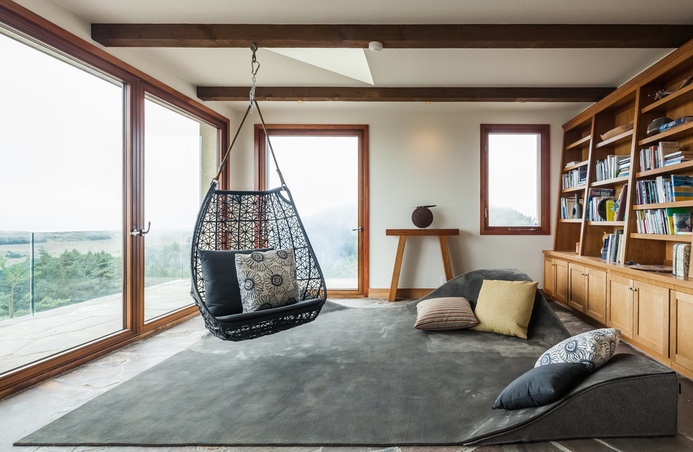 Imagen de sala de estar con biblioteca contemporánea, sin chimenea y televisor, con paredes blancas