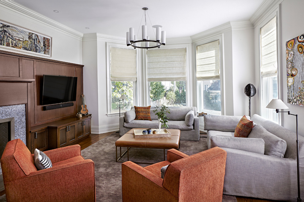 Offenes Klassisches Wohnzimmer mit grauer Wandfarbe, braunem Holzboden, Kamin, gefliester Kaminumrandung und Multimediawand in Chicago