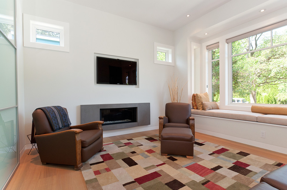 Стильный дизайн: изолированная гостиная комната в современном стиле с белыми стенами, паркетным полом среднего тона, горизонтальным камином и телевизором на стене - последний тренд