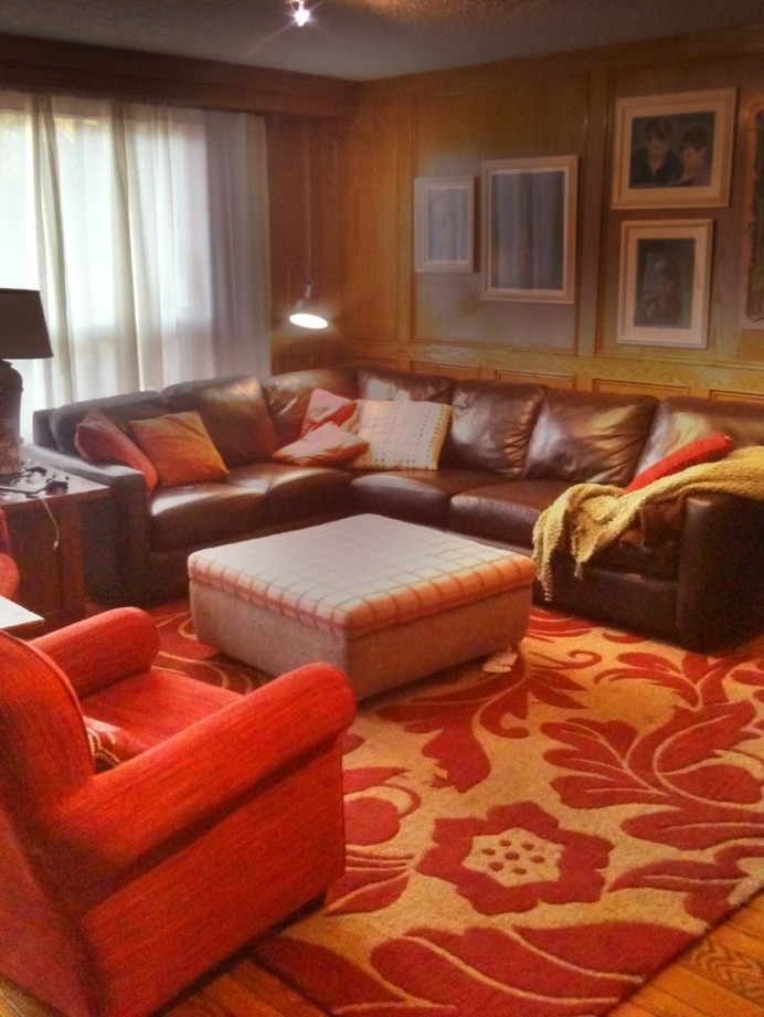 Immagine di un grande soggiorno tradizionale chiuso con pareti marroni, pavimento in legno massello medio, camino classico e cornice del camino in pietra