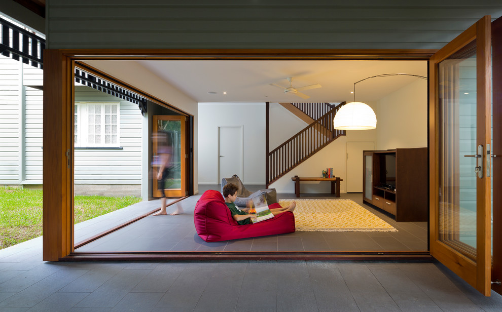 Mittelgroßes, Offenes Modernes Wohnzimmer ohne Kamin mit weißer Wandfarbe, freistehendem TV, Porzellan-Bodenfliesen und grauem Boden in Brisbane