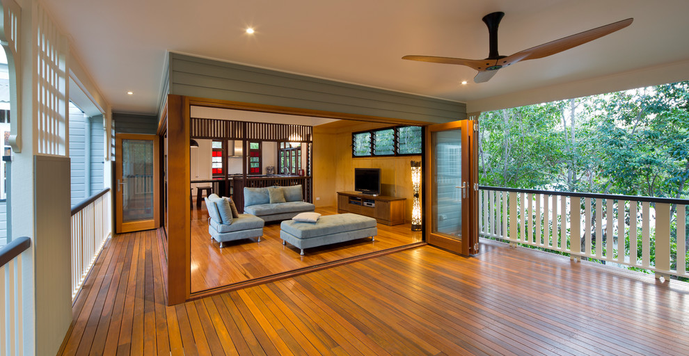 Foto de sala de estar abierta actual sin chimenea con suelo de madera en tonos medios y televisor independiente