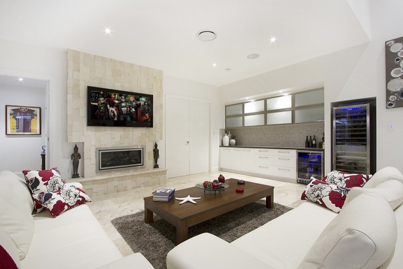 Large contemporary open plan games room in Brisbane with a home bar, white walls, travertine flooring, a two-sided fireplace, a tiled fireplace surround, a wall mounted tv and beige floors.