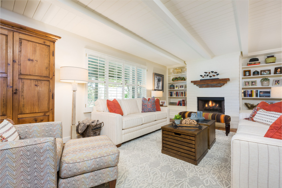 フェニックスにあるお手頃価格の小さなトランジショナルスタイルのおしゃれなオープンリビング (白い壁、テラコッタタイルの床、標準型暖炉、レンガの暖炉まわり、テレビなし、オレンジの床) の写真