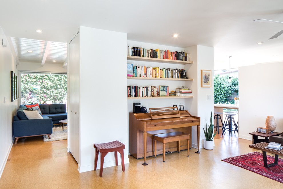 Medium sized midcentury open plan games room in Los Angeles with cork flooring, a music area, white walls, no fireplace, no tv and brown floors.