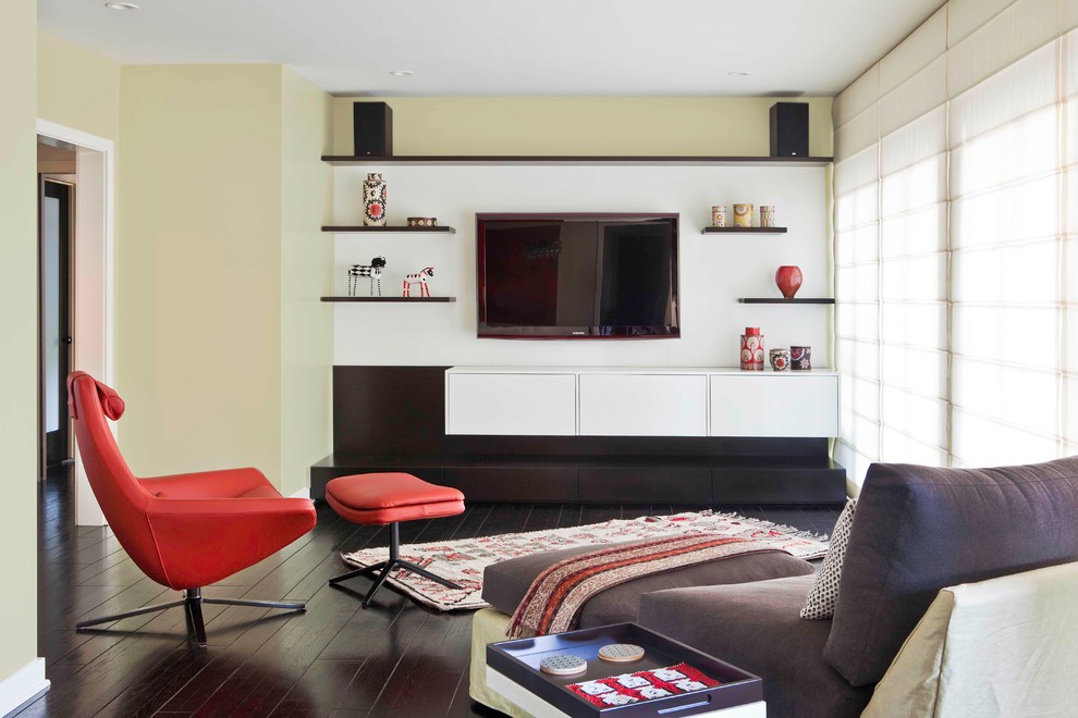 Immagine di un soggiorno moderno con parquet scuro, TV a parete, pareti verdi e tappeto