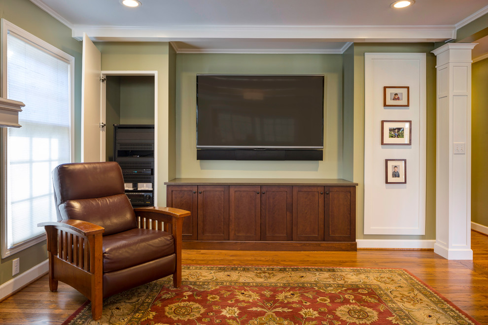 Mid-sized arts and crafts enclosed medium tone wood floor family room photo in Kansas City with green walls, no fireplace and a wall-mounted tv