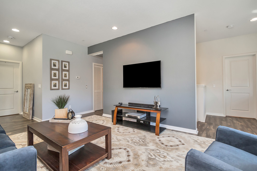 Immagine di un soggiorno classico di medie dimensioni e aperto con pareti grigie, parquet scuro e TV a parete