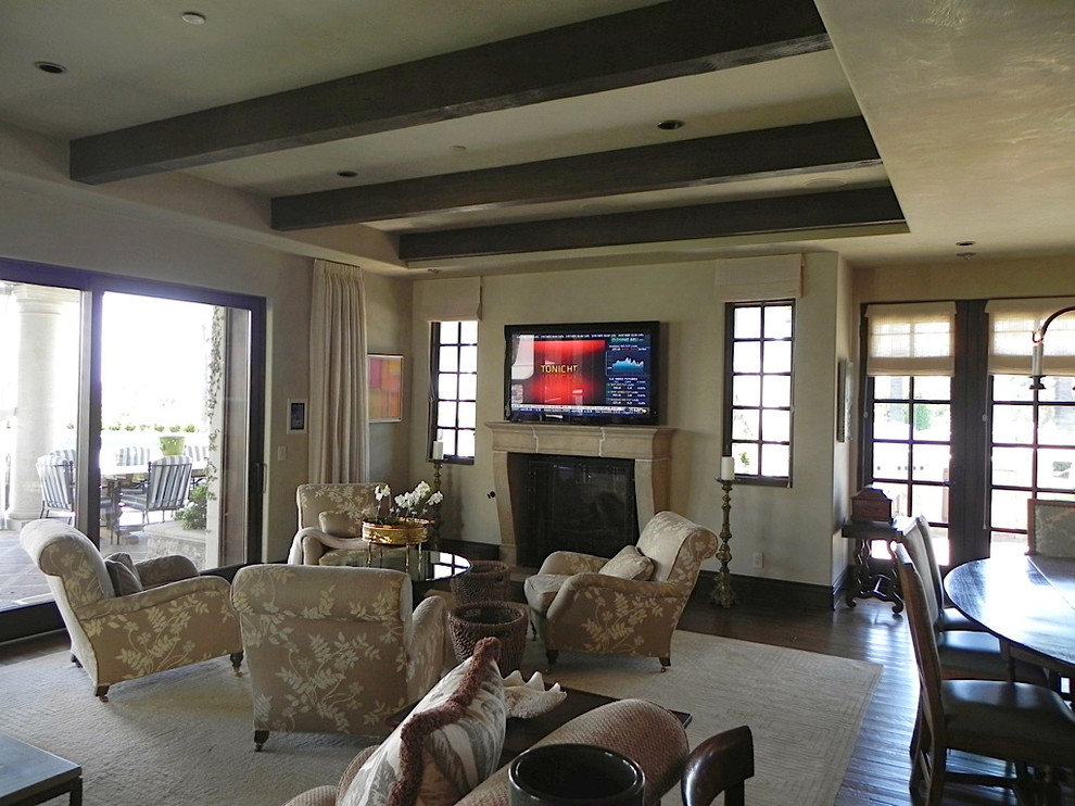 Diseño de sala de estar abierta vintage grande con paredes marrones, suelo de madera oscura, todas las chimeneas y televisor colgado en la pared