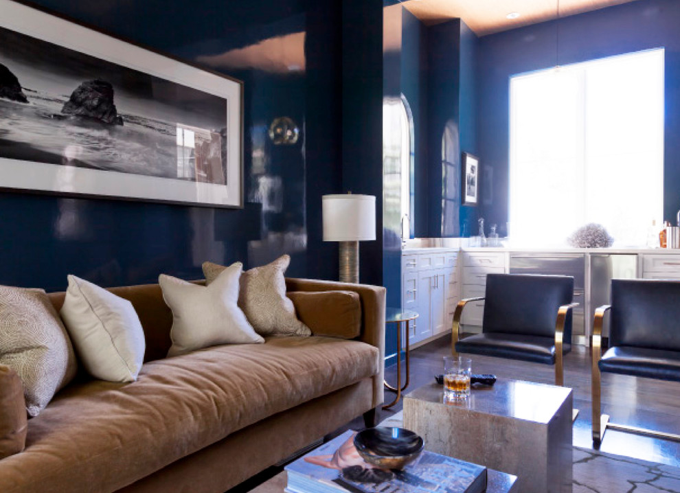 Ejemplo de sala de estar con barra de bar cerrada bohemia de tamaño medio con paredes azules, suelo de madera oscura y televisor colgado en la pared