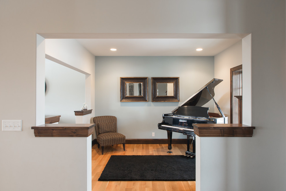 Idée de décoration pour une salle de séjour tradition de taille moyenne et ouverte avec une salle de musique, un mur gris et un sol en bois brun.