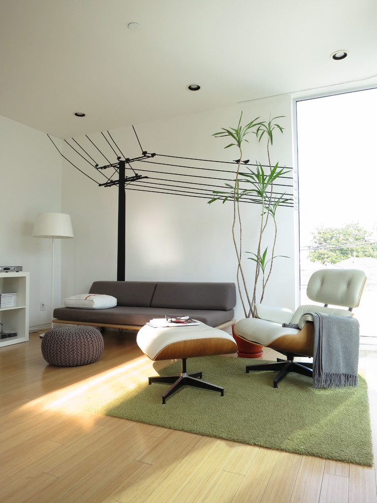 Exemple d'une salle de séjour moderne avec parquet clair, un mur blanc et un sol beige.