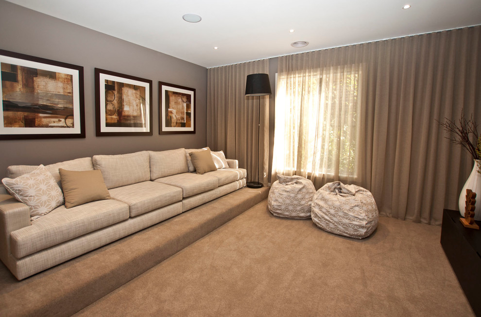 На фото: изолированная гостиная комната среднего размера в стиле модернизм с ковровым покрытием, телевизором на стене и серыми стенами