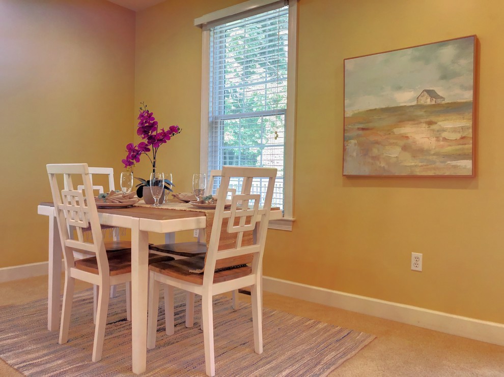 Example of an eclectic dining room design in Philadelphia with yellow walls, a standard fireplace and a wood fireplace surround
