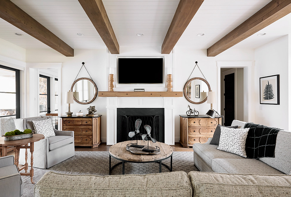 Immagine di un soggiorno costiero con pareti bianche, TV a parete e camino classico