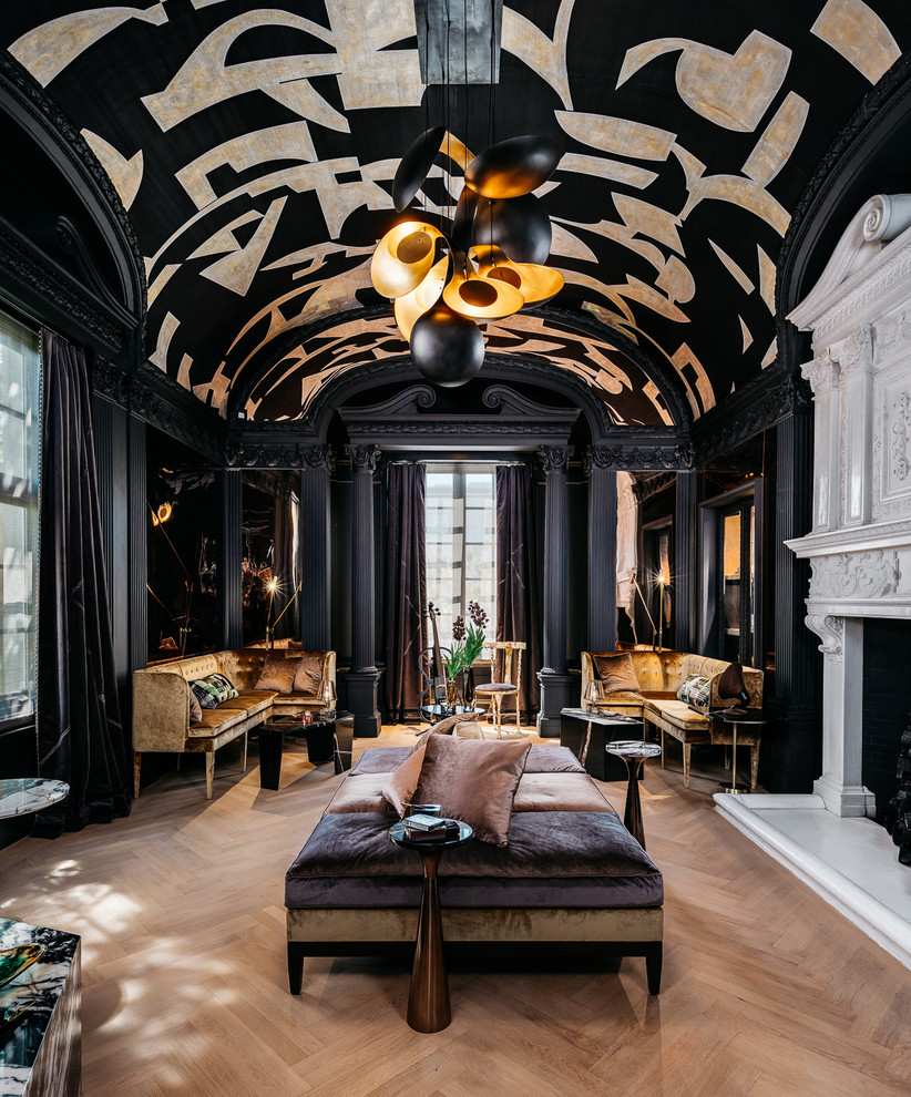 Modelo de sala de estar abierta tradicional grande con paredes negras, suelo de madera clara y suelo beige
