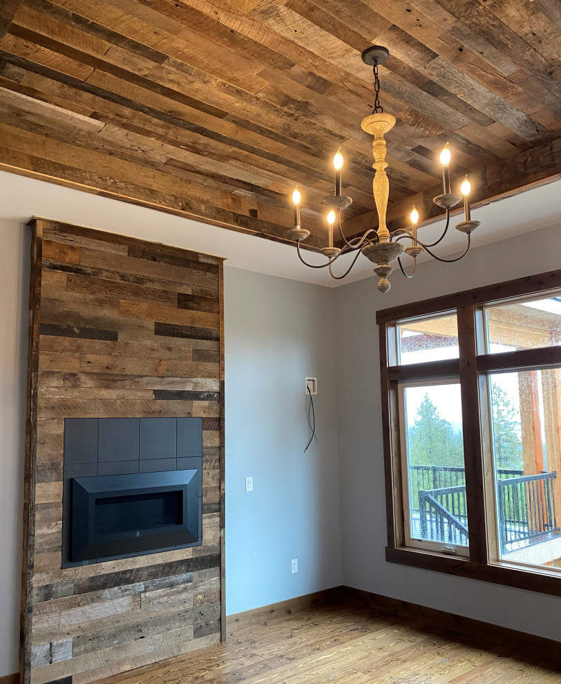 Aménagement d'une salle de séjour montagne en bois de taille moyenne et ouverte avec un sol en bois brun, cheminée suspendue, un manteau de cheminée en bois, un sol marron et un plafond en bois.