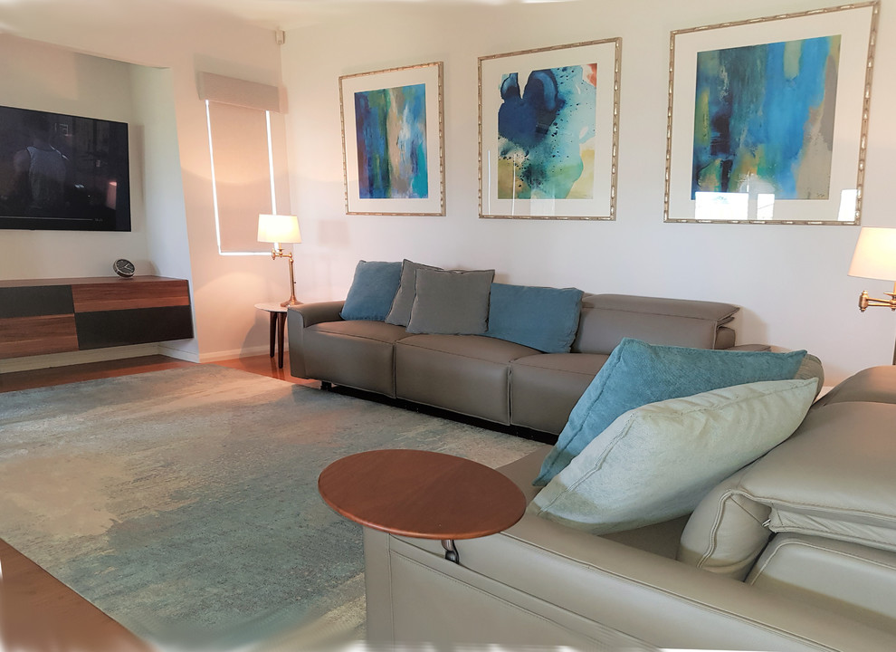 Foto de sala de estar abierta clásica renovada de tamaño medio con paredes blancas, suelo de madera en tonos medios, televisor colgado en la pared y suelo marrón
