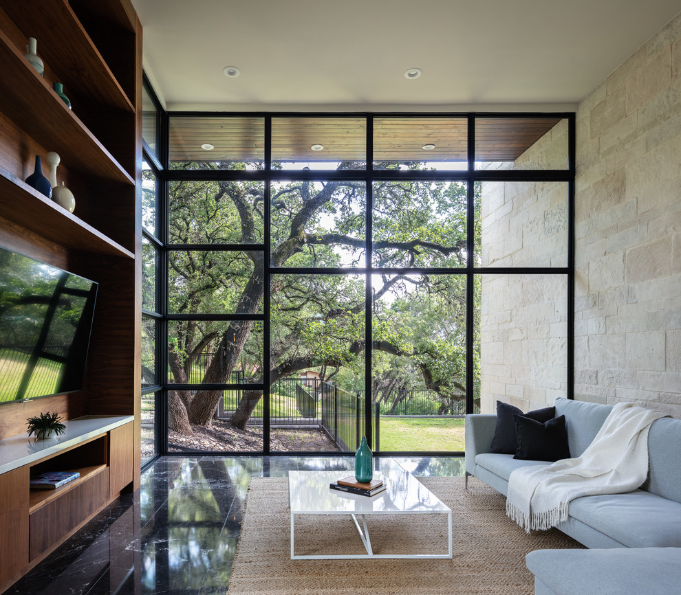 Idée de décoration pour une salle de séjour design avec un mur beige, un sol en marbre, un téléviseur fixé au mur et un sol noir.