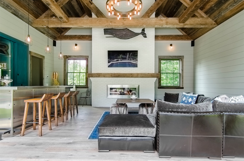 Small beach style open plan games room in New York with white walls, light hardwood flooring, a standard fireplace and a brick fireplace surround.