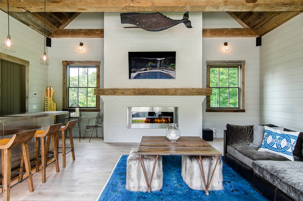 Inspiration for a small coastal open concept light wood floor family room remodel in New York with white walls, a wall-mounted tv, a bar, a standard fireplace and a brick fireplace