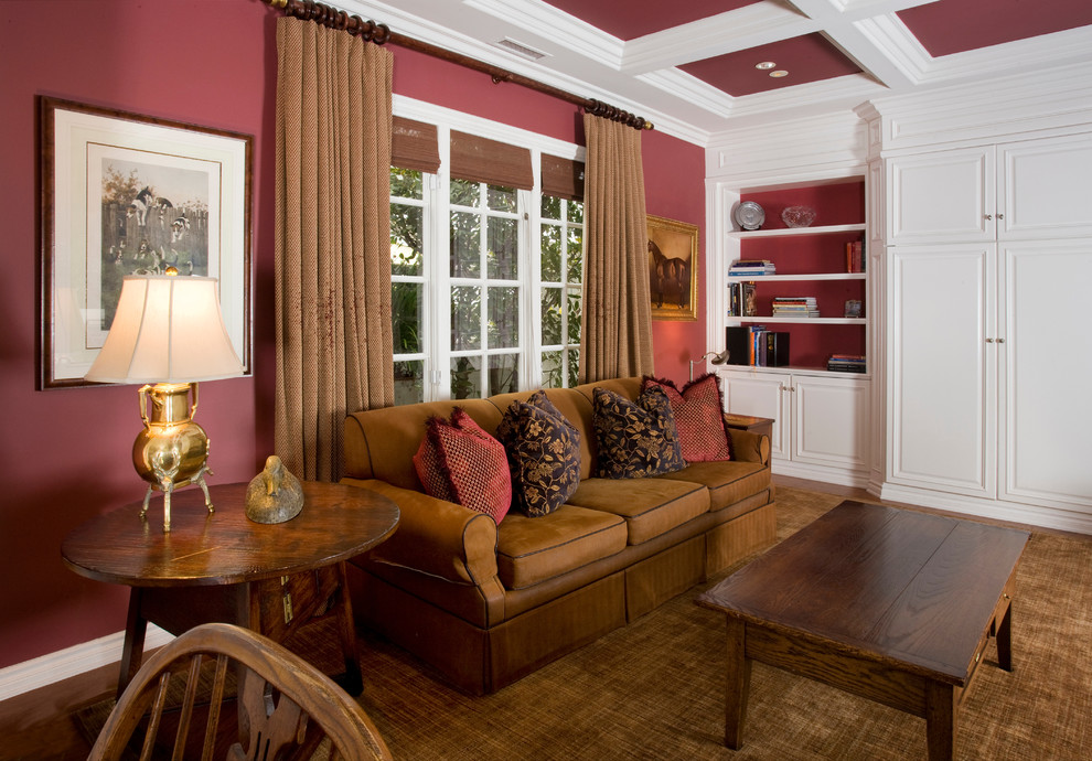 На фото: изолированная гостиная комната в классическом стиле с красными стенами и коричневым диваном с