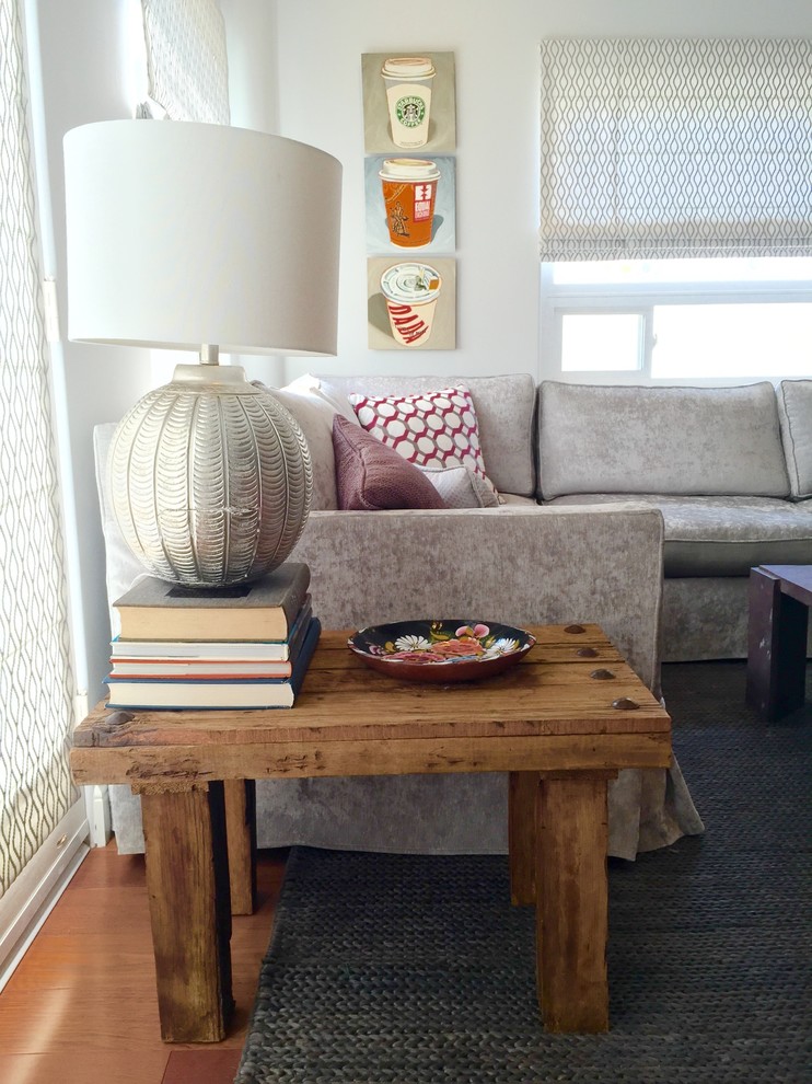 Imagen de sala de estar abierta clásica renovada de tamaño medio con paredes grises, suelo de madera en tonos medios y televisor colgado en la pared